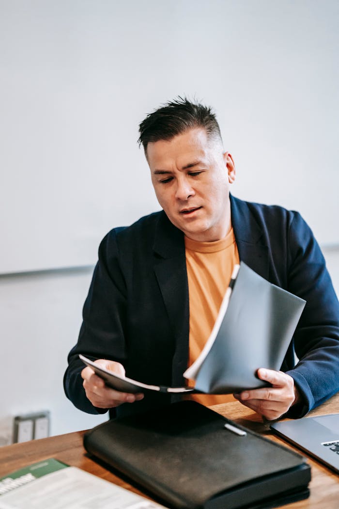 services-header Businessman in a suit reviewing documents at an office desk, focused on work.
